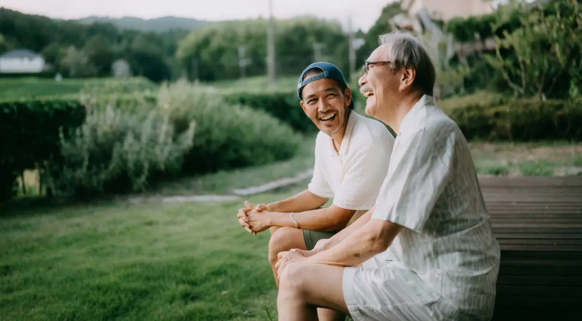 Senior father and adult son having fun on patio